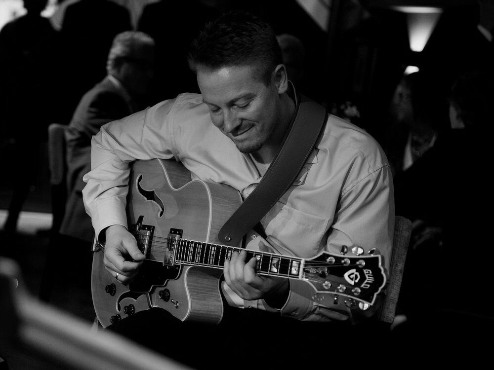 Alexander Stakenburg playing archtop guitar during a performance